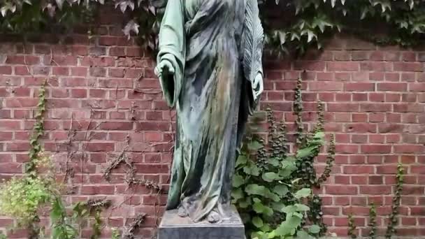 Bronzen standbeeld van een spirituele engel figuur op een kerkhof als culturele heilige geest en ziel geschiedenis op het kerkhof als bewaker van de doden en iconische monument symbool voor religieuze graven met vleugels - Video