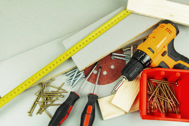 tools for repair and construction. Screwdriver, furniture screws, measuring tape, self-tapping screws, with a place for text. Top view. - Foto, Imagen