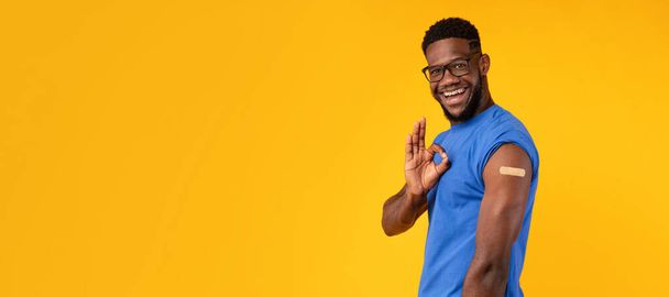 Vaccinated Black Guy Gesturing Okay Showing Arm, Yellow Background, Panorama - Photo, Image