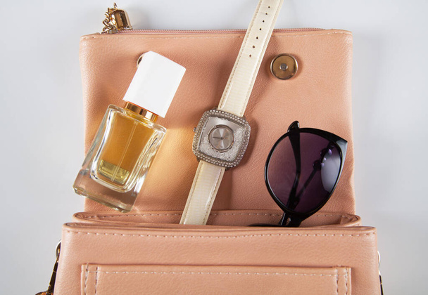 Women's accessories on a white background. Perfume, sunglasses and watch. Concept of fashion. - Photo, Image