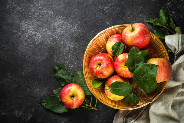 Fresh ripe red apples in the basket at white table. - 写真・画像