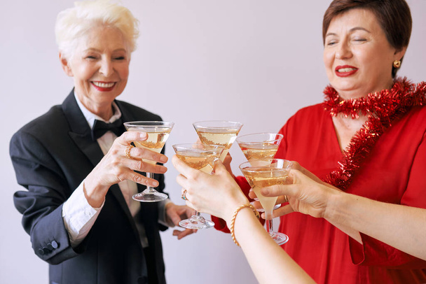 Újév ünnepli kezeit egy pohár fehér pezsgővel. Karácsony, család, barátok, ünneplés, újév koncepció - Fotó, kép