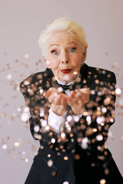 κοντά μαλλιά κομψή ηλικιωμένη γυναίκα σε σμόκιν με glitter γιορτάζει το νέο έτος. Διασκέδαση, τρόπος ζωής, στυλ, έννοια της ηλικίας - Φωτογραφία, εικόνα