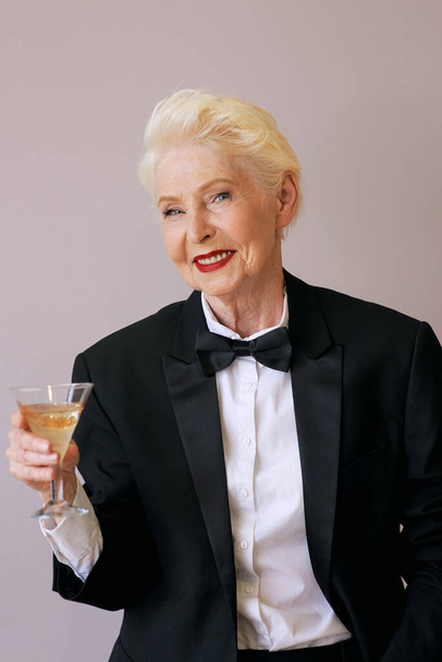 sommelier mature élégante femme âgée en smoking avec un verre de vin mousseux. Fun, fête, style de vie, alcool, concept de célébration - Photo, image