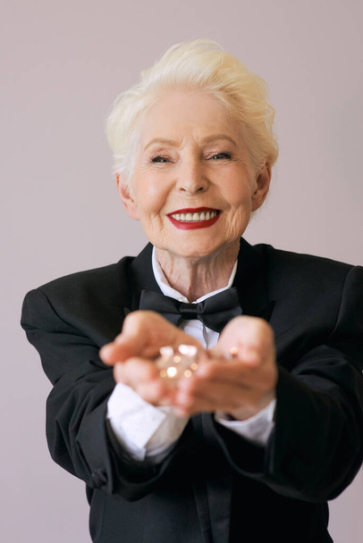 κοντά μαλλιά κομψή ηλικιωμένη γυναίκα σε σμόκιν με glitter γιορτάζει το νέο έτος. Διασκέδαση, τρόπος ζωής, στυλ, έννοια της ηλικίας - Φωτογραφία, εικόνα