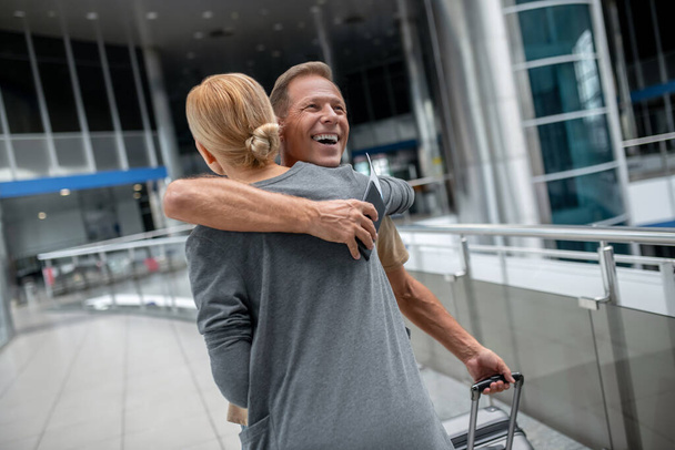 Man with suitcase hugging blonde woman - Foto, Imagem