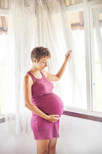Pregnant woman near the window - Foto, Bild