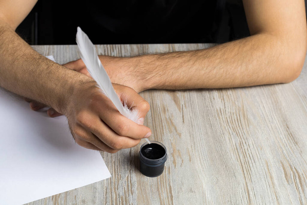 Bir adamın eli mürekkep hokkasına tüy kalem batırır. Şiir ve gazetecilik sembolü. Metin yazma kavramı. Arkaplan - Fotoğraf, Görsel