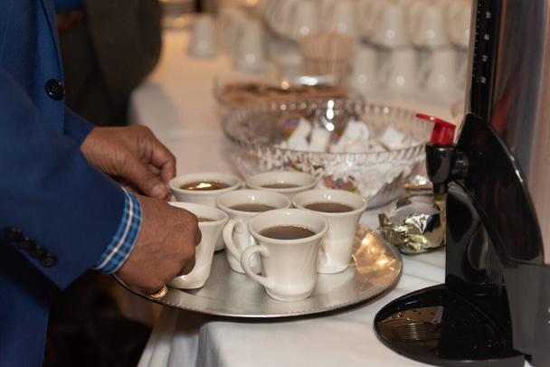 Сваренный кофе, сложенный на подносе, чтобы принести семье выпить на банкетном ужине. - Фото, изображение