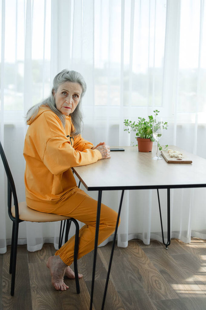 Portrét krásné staré babičky s šedými vlasy a obličejem s vráskami při pohledu do kamery, Den matek, šťastný odchod do důchodu - Fotografie, Obrázek