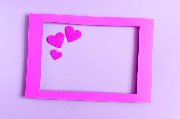 A colorful frame decorated with pink hearts on a light background of kopi space. Flat Lei Hot Pink Paper Frame and heart-shaped decor - Fotografie, Obrázek