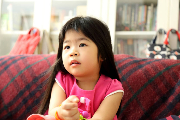 La chica asiática viendo televisión en la sala de estar. - Foto, Imagen