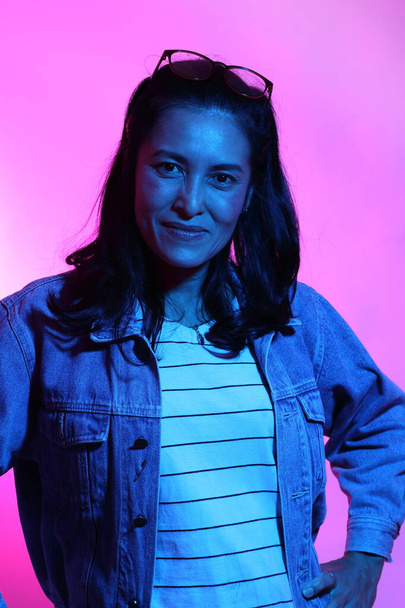 The Asian woman posing in the color gel light. - Foto, Bild