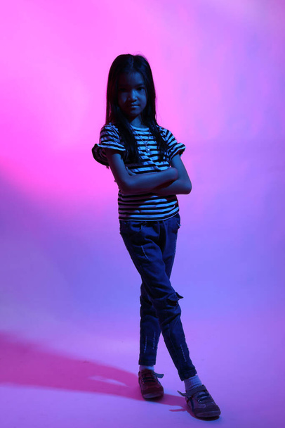 The Asian girl posing in the color gel light. - Foto, afbeelding