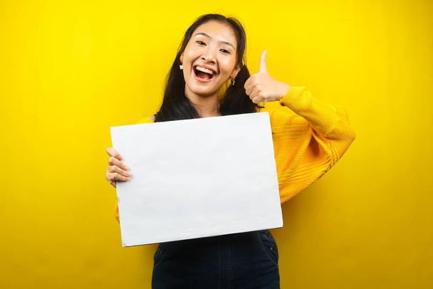 Pretty and cute young woman cheerful holding blank empty banner, placard, white board, blank sign board, white advertisement board, presenting something in copy space, promotion - Foto, Imagem