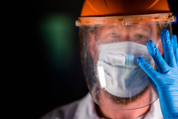 Covid Arzt und Mitarbeiter im Gesundheitswesen, setzt eine Maske und einen Gesichtsschutz auf, während er einen Labormantel und Handschuhe in Australien trägt. - Foto, Bild