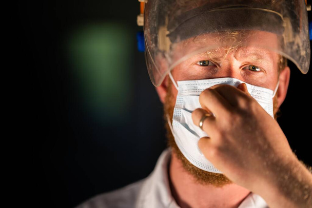 Covid médico, enfermeiro e profissional de saúde, colocar uma máscara e protetor facial, enquanto vestindo um jaleco e luvas na Austrália. tomado num hospital durante a pandemia. - Foto, Imagem
