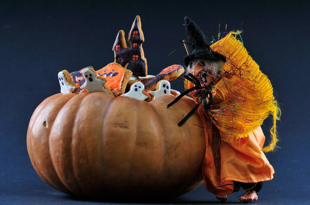 Halloween-Leckereien. Lebkuchen in Kürbis auf dunklem Hintergrund. - Foto, Bild