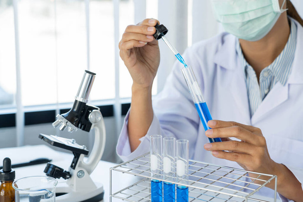Scientist wear lab coat and protective wear are working with research or doing investigations with test tubes in experiment, Laboratory and development concept. - Photo, Image
