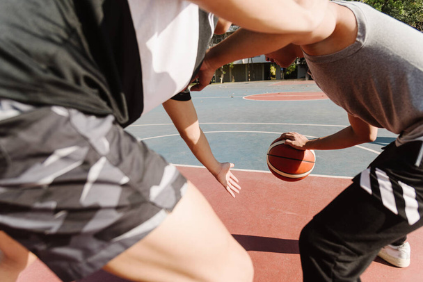 Concepto de deportes y recreación jóvenes adolescentes varones practicando baloncesto regateado en la cancha después de la escuela. - Foto, Imagen