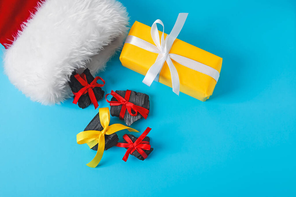 Weihnachtssocke mit Kohle und Geschenk auf farbigem Hintergrund - Foto, Bild