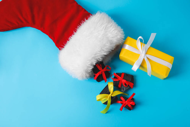 Skarpetka świąteczna z węglem i prezentem na tle koloru - Zdjęcie, obraz