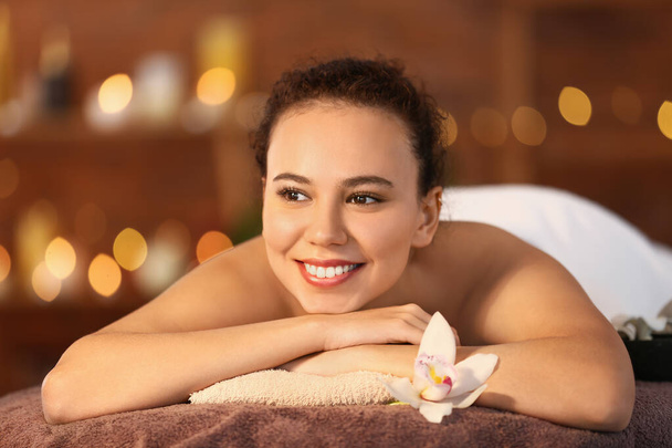 Belle jeune femme afro-américaine relaxante dans un salon de spa - Photo, image