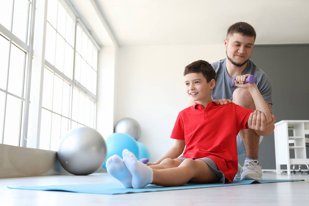 Physiotherapeut arbeitet mit Junge im Reha-Zentrum - Foto, Bild