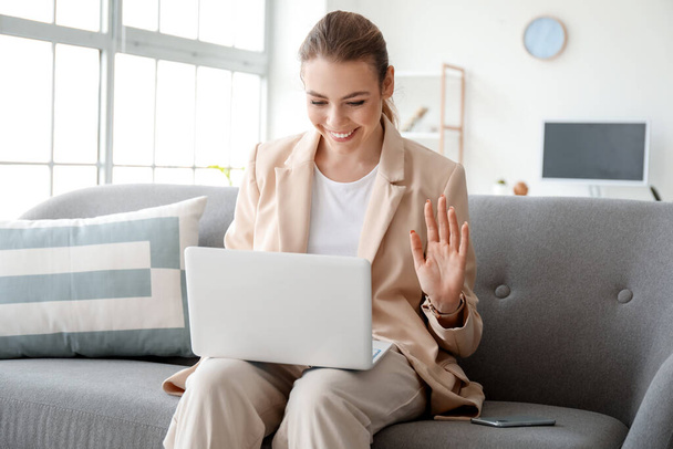 Mujer joven con el ordenador portátil de chat de vídeo en casa
 - Foto, Imagen