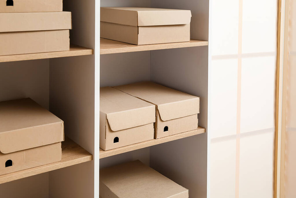 Muchas cajas de cartón en estantes en el armario - Foto, imagen