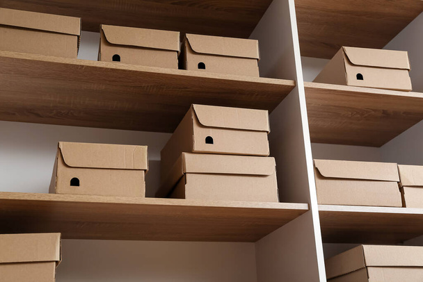 Πολλά κουτιά από χαρτόνι στα ράφια της ντουλάπας - Φωτογραφία, εικόνα