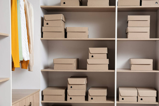 Wiele kartonowych pudełek na półkach w szafie - Zdjęcie, obraz