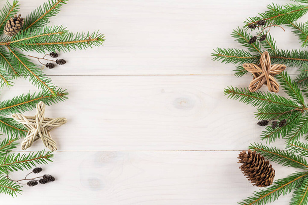 白い木の背景にコーンと星のある平らな枝。クリスマスと新年のコンセプト。水平方向、コピースペース、上のビュー. - 写真・画像