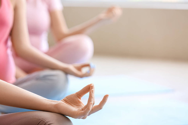 Junge schwangere Frauen praktizieren Yoga im Fitnessstudio, Nahaufnahme - Foto, Bild