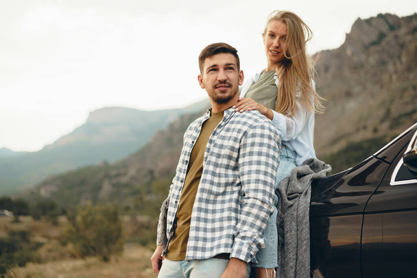 Young couple is on romantic trip to the mountains by car - 写真・画像