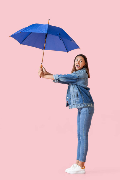 Beautiful young woman with umbrella on color background - Foto, Imagen