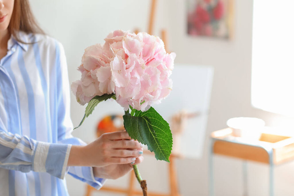 自宅でアジサイの花を持つ若い女性 - 写真・画像