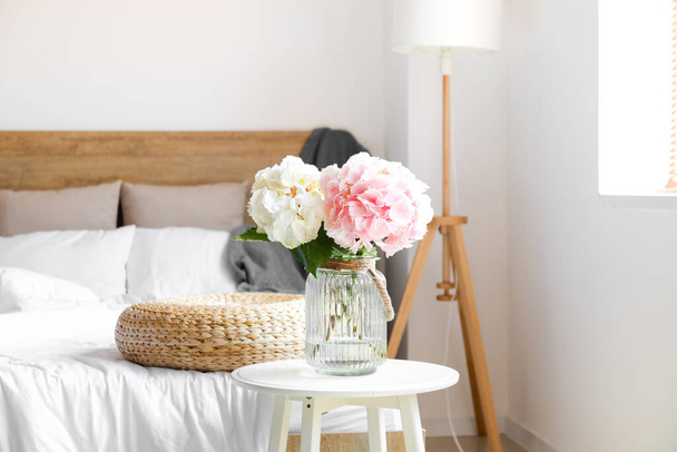 Jarrón con flores de hortensias en la mesa en el dormitorio - Foto, Imagen