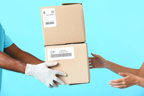 Customer receiving parcel from courier on color background - Photo, Image