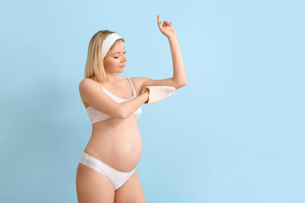 Красива вагітна молода жінка з масажем, пом'якшена на кольоровому фоні
 - Фото, зображення