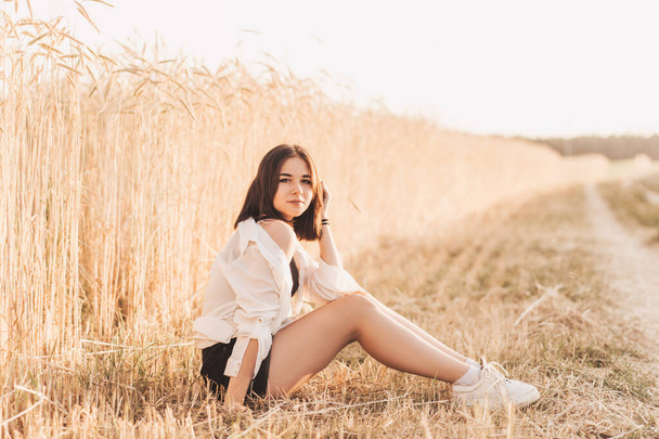 Teenage girl walks alone in nature in the summer. Schoolgirl with black hair relaxing - Photo, Image