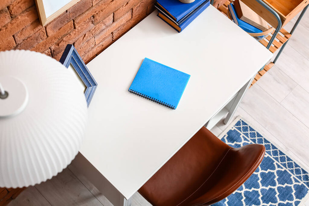 Stijlvolle werkplek met notebook op tafel in de buurt van bakstenen muur - Foto, afbeelding