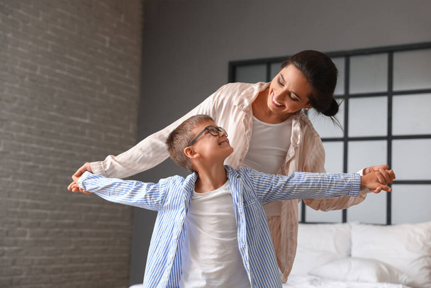 Young woman and her little son dancing in bedroom - Photo, Image