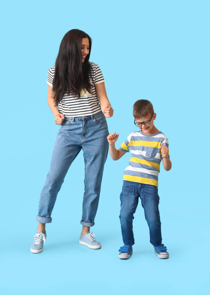 Dancing young woman and her little son on color background - Fotografie, Obrázek
