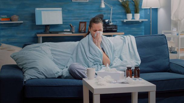 Unhappy woman with flu using tissue to blow runny nose - Photo, Image