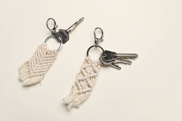 Κλειδιά με χειροποίητα βαμβακερά μπρελόκ σε ελαφρύ φόντο - Φωτογραφία, εικόνα