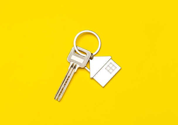 Sleutel met huisvorm sleutelhanger op kleur achtergrond - Foto, afbeelding