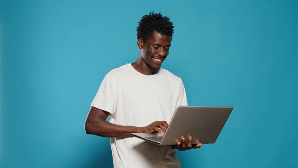 Africano americano homem usando laptop para entretenimento - Foto, Imagem
