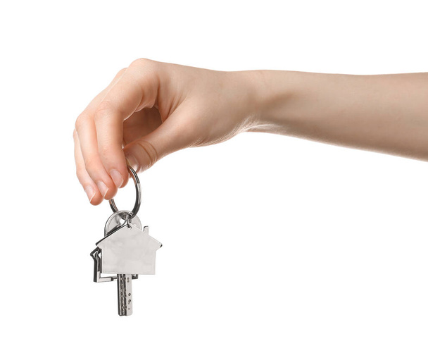 Female hand with key and house shape keychain on white background - Фото, зображення