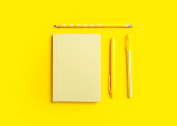 Stylish notebook, pens and pencil on color background - Foto, afbeelding